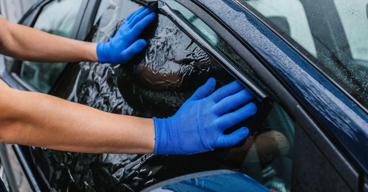Meccanico installa pellicole oscuranti per vetri auto anteriori