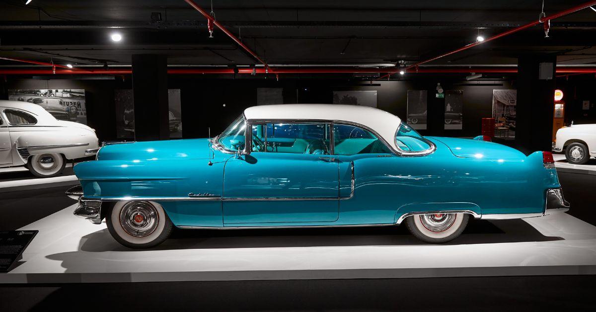 Auto d'epoca azzurra con tetto bianco esposta in un museo automobilistico